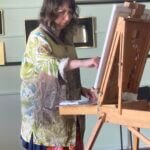 Esther Deans in front of an easel, painting